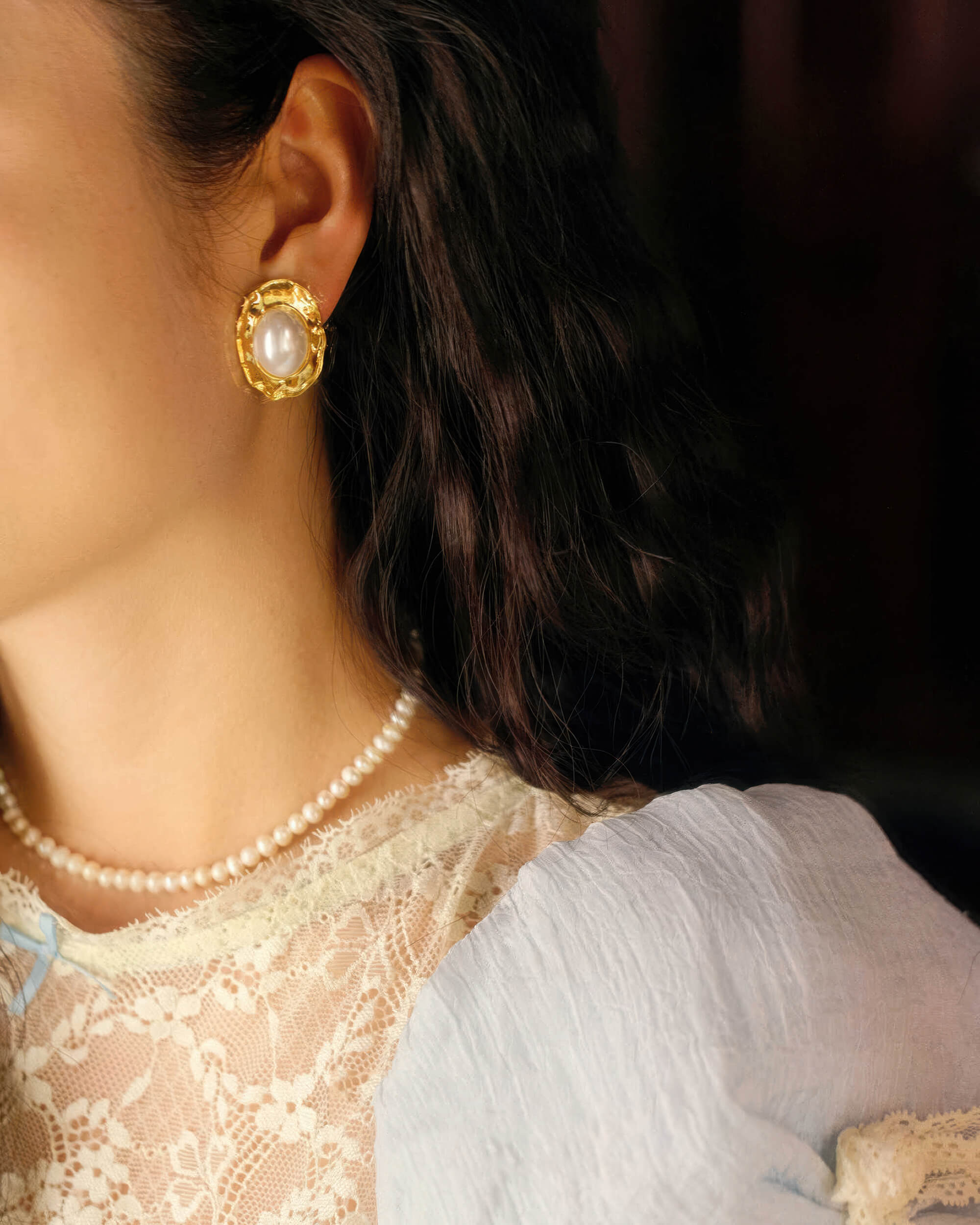 Front view of the 18K gold plated oval Mabe pearl statement earrings with a detailed gold rope edge.