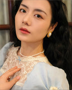 Model wearing the vintage-style oval pearl earrings, showcasing their elegant large-scale design.