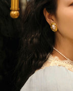 Side profile of the large gold-rimmed pearl earrings, emphasizing the secure fit and high-quality craftsmanship.