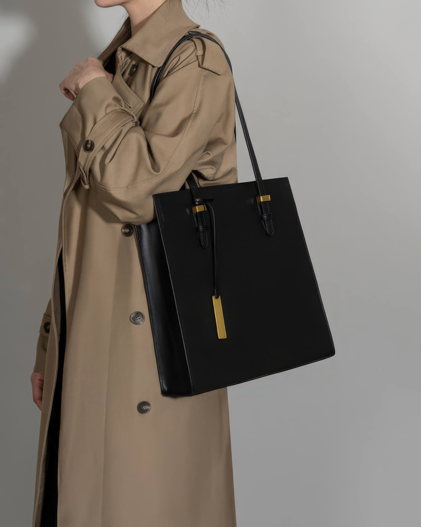 Professional woman carrying a large black leather tote bag, ideal for office or daily use.