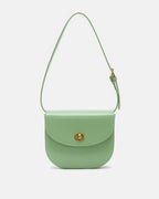 Front view of a sage green classic leather flap saddle crossbody bag with a gold turn-lock closure on a plain background.
