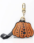 Orange dotted pumpkin leather charm featuring a gold metal clasp and leather strap.