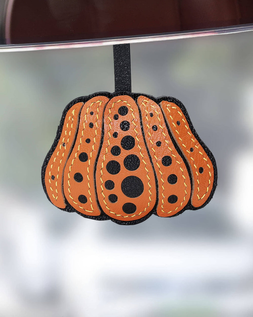 Orange dotted pumpkin leather charm hanging as a cute handbag accessory or rearview mirror charm.