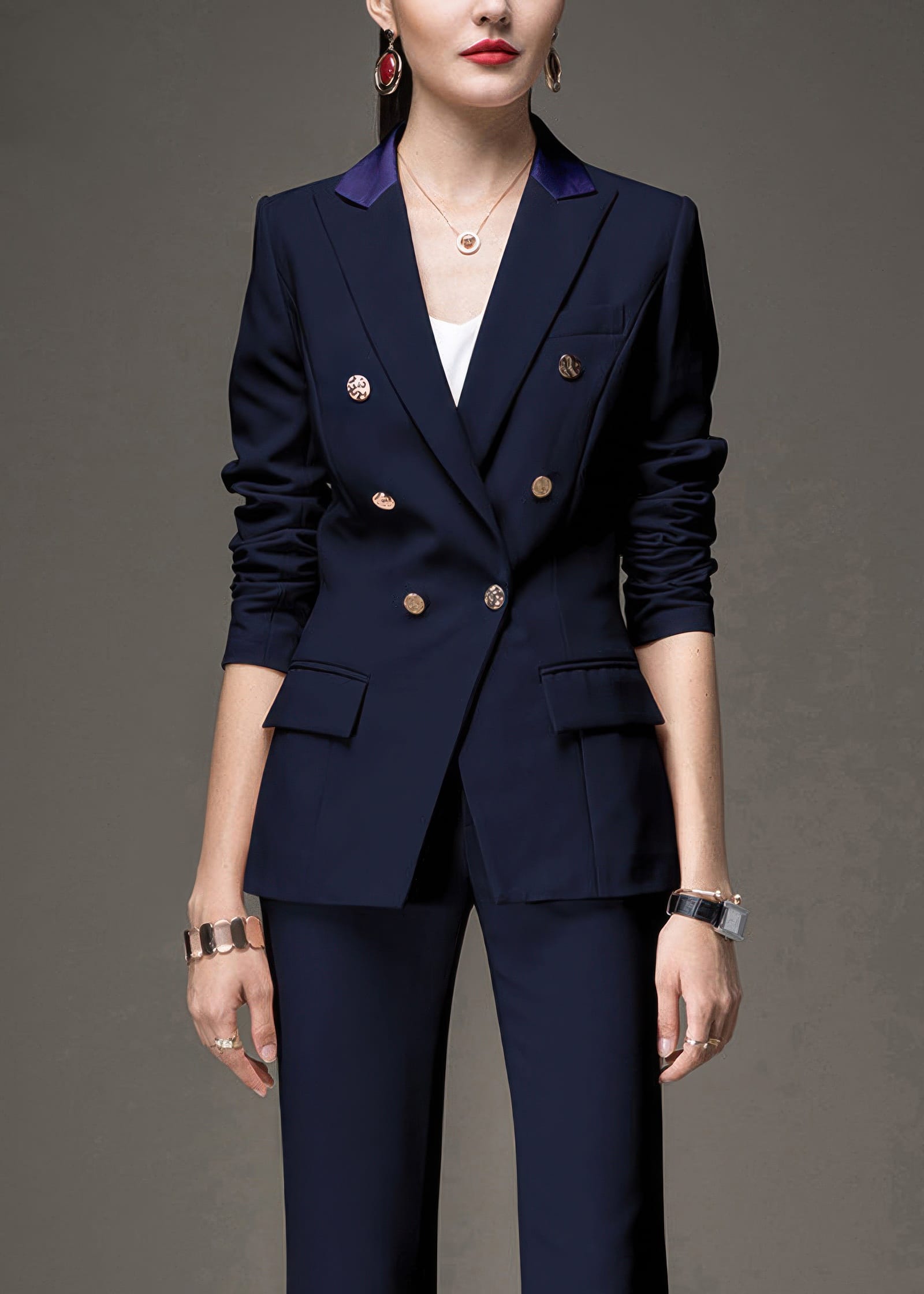 Close-up of a woman in a navy blue double-breasted blazer with purple lapel accents and gold buttons.