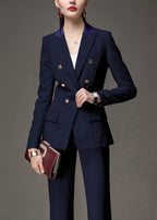 Three-quarter view of a woman in a navy blue tailored suit, accessorized with a watch and a burgundy clutch.
