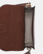 Top-down interior view of an open dark brown leather flap crossbody bag, showing the herringbone fabric lining and main compartment.