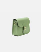 Side three-quarter angle of a sage green leather flap crossbody bag showing strap attachment rings and gold hardware.