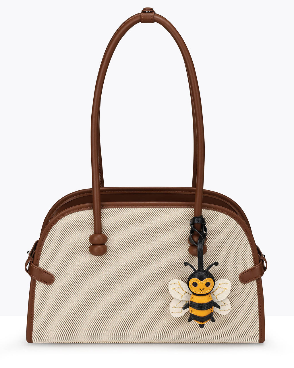 Beige canvas tote bag decorated with a honeybee French goatskin leather bag charm hanging on the strap.