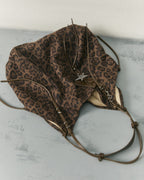Flat lay view of soft slouchy brown leopard print faux suede shoulder bag resting on grey textured surface