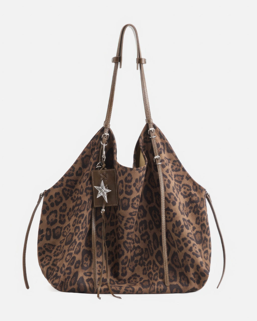 Front view studio product shot of a brown leopard print faux suede slouchy tote bag with leather straps and star pendant