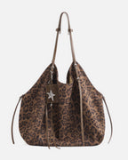 Front view studio product shot of a brown leopard print faux suede slouchy tote bag with leather straps and star pendant