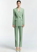 A full-length front view of the model wearing the mint green slim-fit suit with straight-leg trousers and white heels with gold buckle details.
