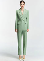 A full-length front view of the model wearing the mint green slim-fit suit with straight-leg trousers and white heels with gold buckle details.