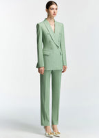 A full-length three-quarter view of the model standing, emphasizing the clean lines and structured shoulders of the mint green blazer.