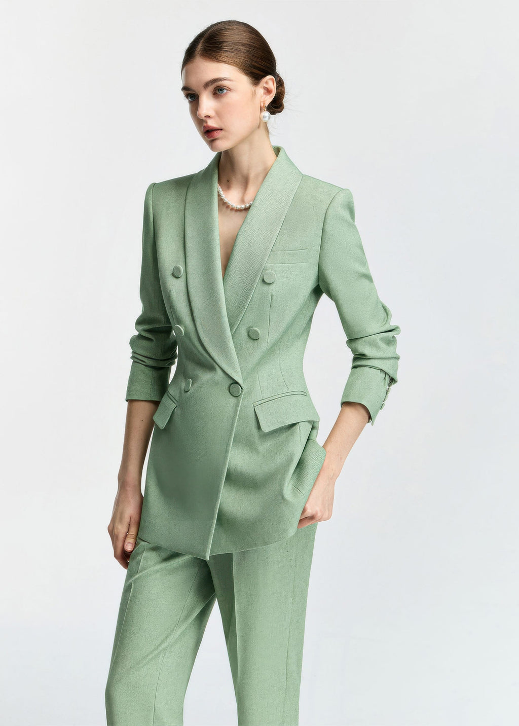 A medium shot from a slight angle, highlighting the textured fabric of the blazer and the model's sophisticated styling.