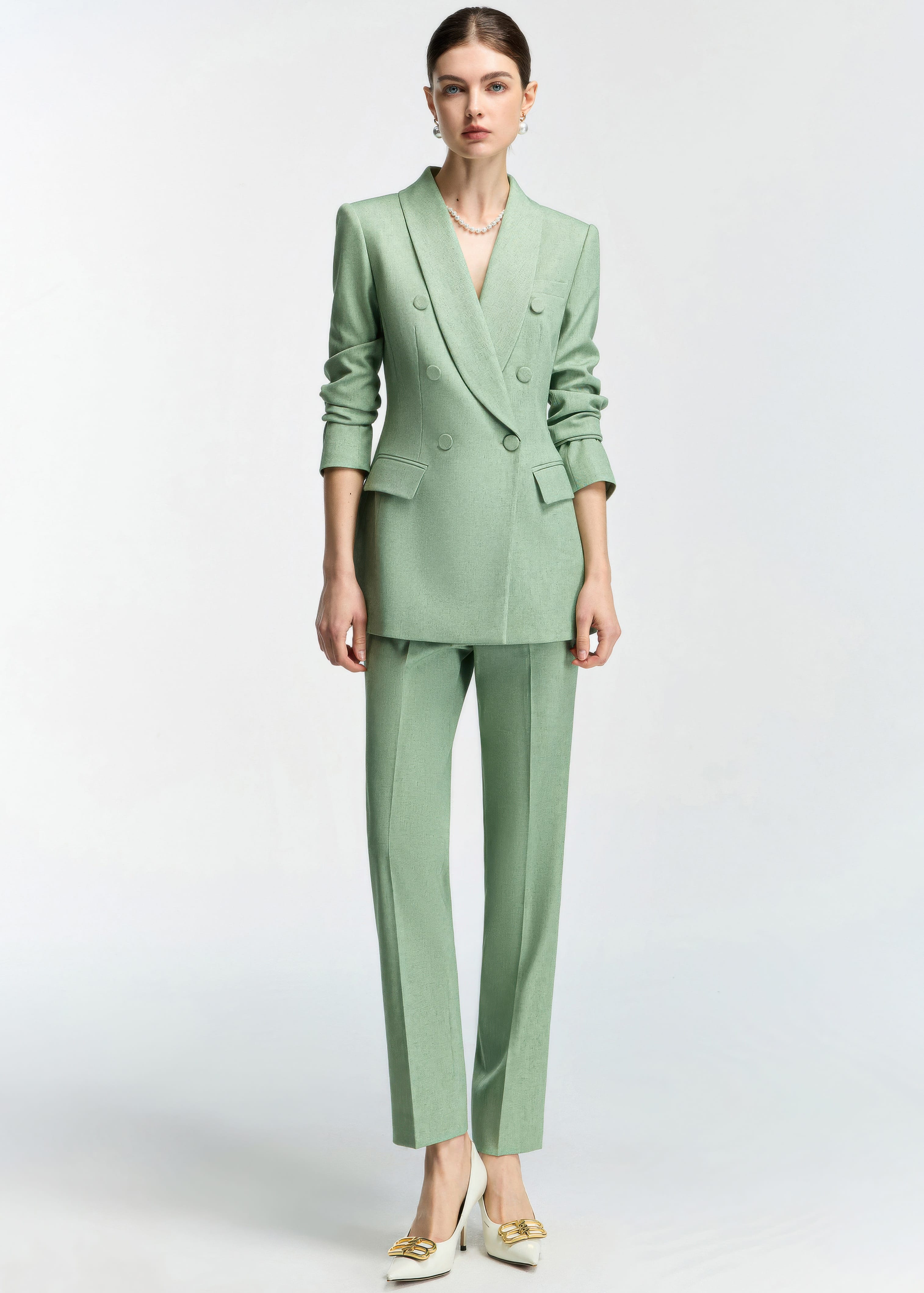 A full-length studio shot of the model in a neutral pose, displaying the complete mint green slim-fit ensemble against a white background.