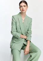 A medium shot of a model sitting, showcasing the texture and button details of the mint green blazer.