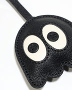 Macro detailed view of textured French goatskin leather and fine stitching on ghost bag charm.