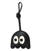 Playful black ghost leather bag charm with big cartoon eyes on plain background.