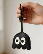 Hand holding a black ghost leather bag charm showing size and strap length.