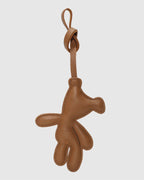 Back view of a brown leather teddy bear bag charm showing smooth back stitching and goatskin leather texture.