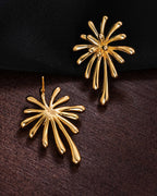 Front and back view of the 18K gold plated burst earrings on a dark textured surface, showing the secure stud post.