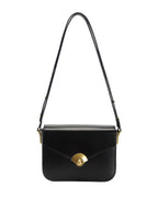 Black leather flap crossbody bag with vintage gold turn-lock hardware and adjustable shoulder strap on white background.