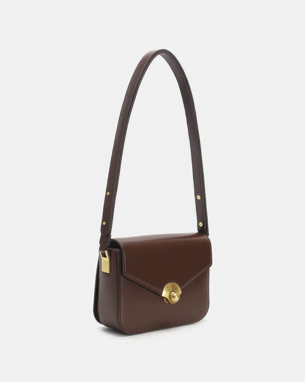 Side three-quarter angle of a brown leather flap crossbody bag showcasing the gold turn-lock closure.