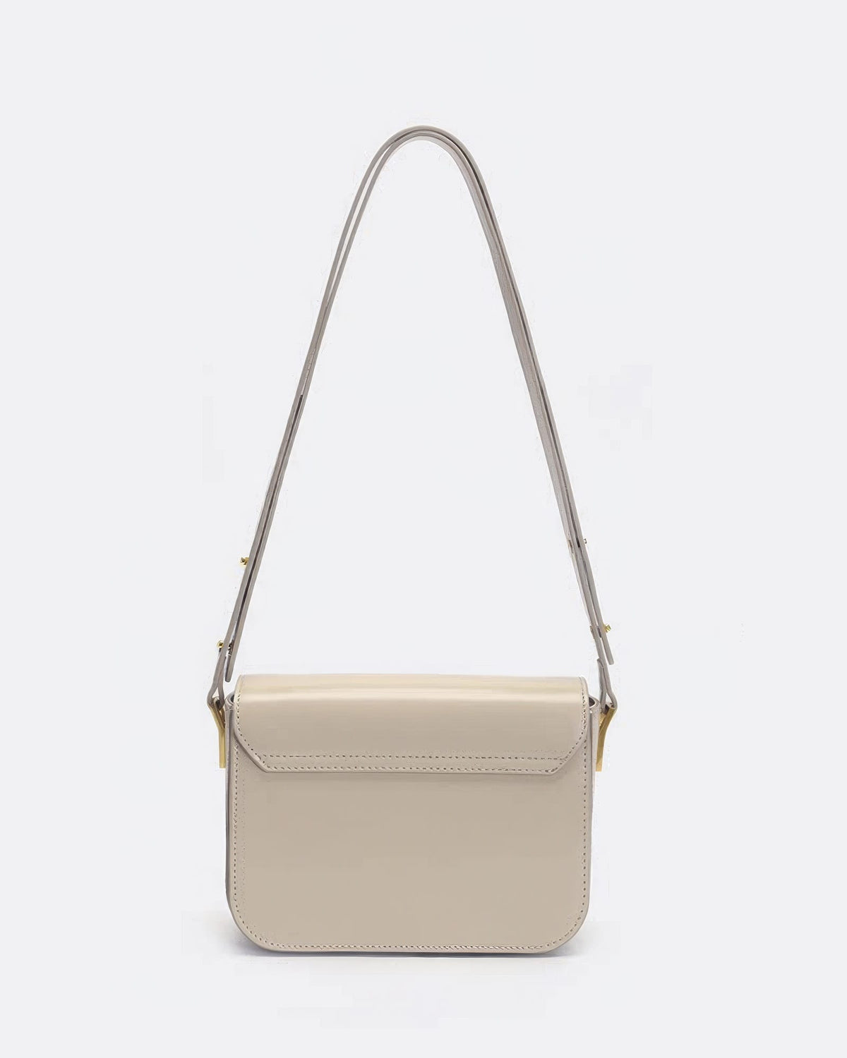 Rear view of an off-white smooth leather shoulder bag with clean stitching and gold strap connectors.