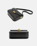 Two-angle product shot showing the top and bottom exterior of a black leather turn-lock crossbody bag.