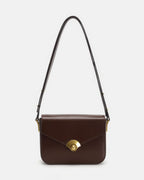 Dark brown leather flap shoulder bag featuring a gold fan-shaped turn-lock closure on white studio background.