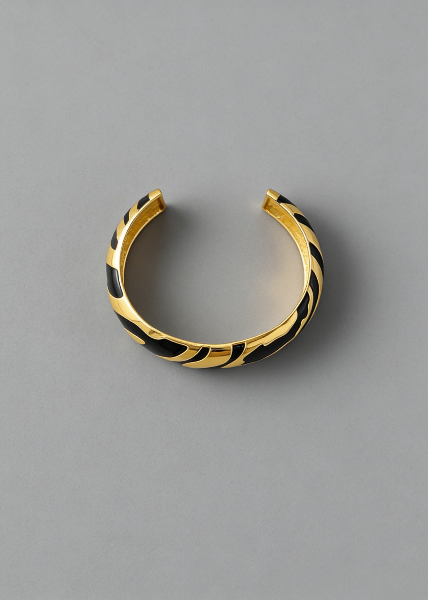 Overhead view of the black and gold Vintage Zebra Stripe Enamel Cuff Bracelet showing the open-back adjustable cuff style.