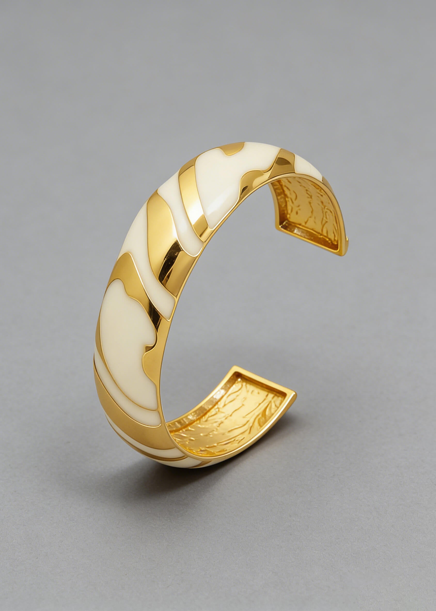 Angled view of the Vintage Zebra Stripe Enamel Cuff Bracelet in cream and gold highlighting the smooth enamel curves.