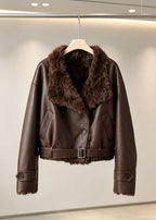 Front view of a women's dark brown faux leather aviator jacket with a buckled belt hanging on a rack.