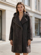 Model showcasing a dark grey oversized long hooded shearling wool teddy coat in an urban setting