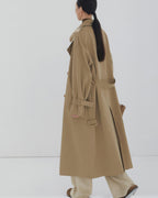 Back view of a women's long oversized trench coat showing classic storm flap and center vent detail.