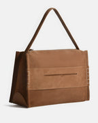 Three-quarter studio angle of the tan suede bag, highlighting the reinforced bottom corners and white whipstitch detailing.