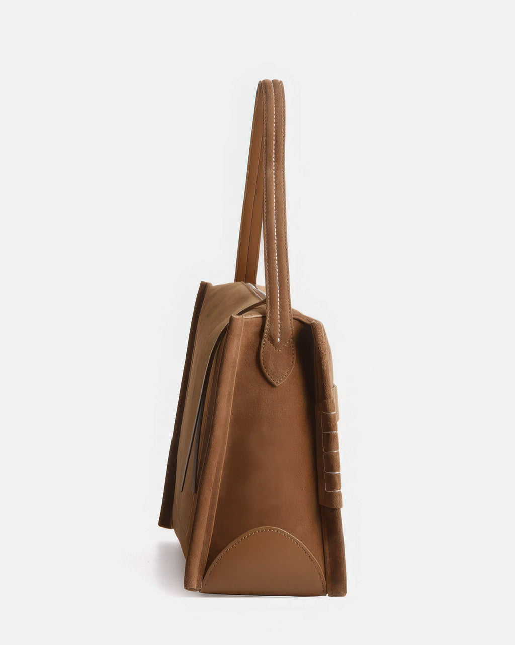 Profile view of the suede shoulder bag, showcasing the slim side gusset and the durable attachment of the leather shoulder strap.