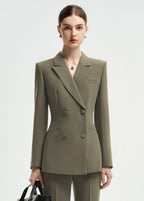 A medium shot of a woman wearing an olive green double-breasted tailored blazer, showcasing the lapel and button details.