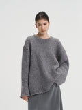 Front view of a women's oversized chunky wool blend knit sweater in heather grey, styled with a matching grey maxi skirt.