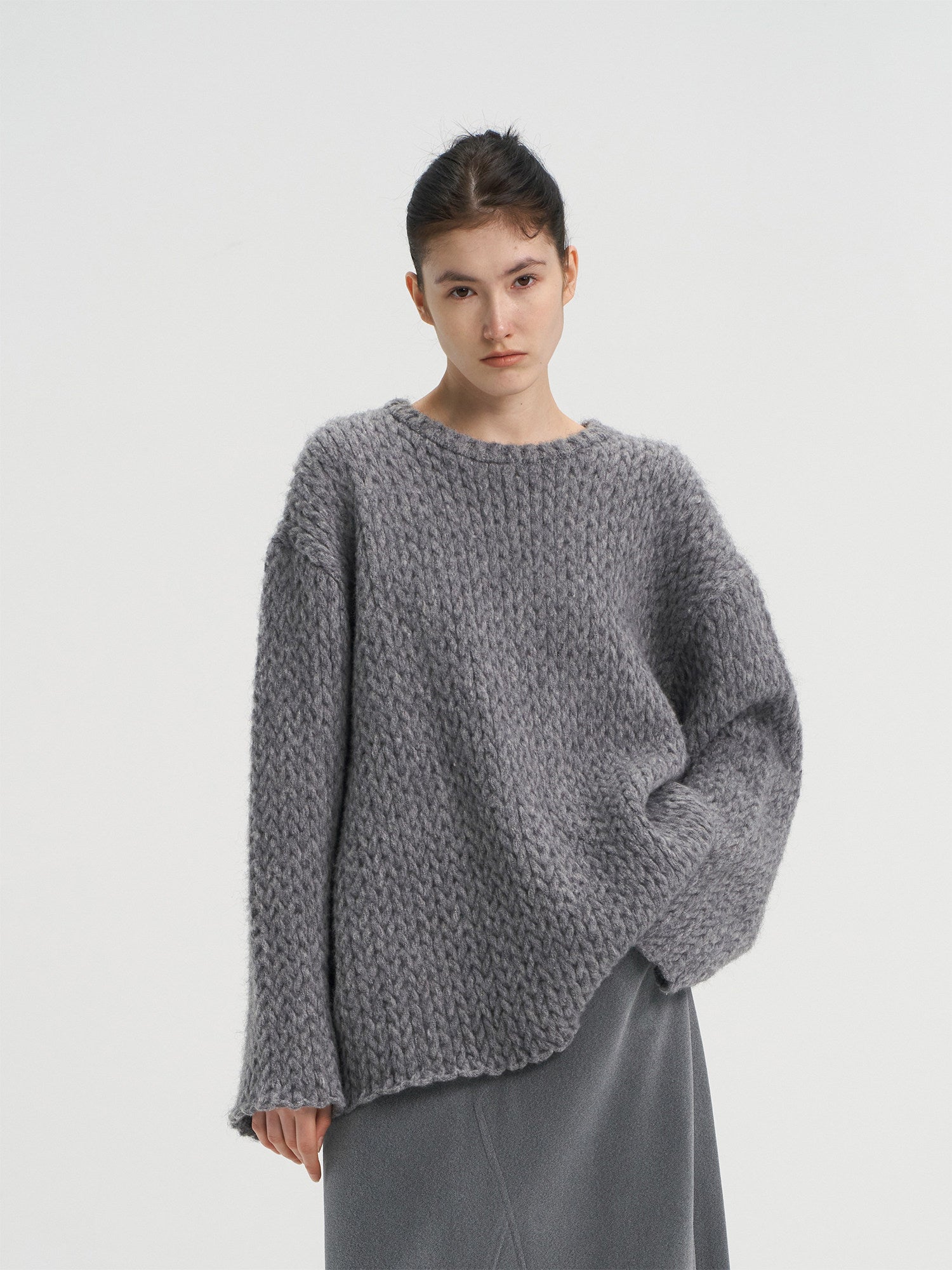 Front view of a women's oversized chunky wool blend knit sweater in heather grey, styled with a matching grey maxi skirt.