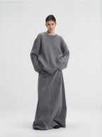Front view of a women's oversized chunky wool blend knit sweater in heather grey, styled with a matching grey maxi skirt.