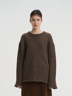 Close-up front view of a women's chocolate brown oversized wool blend sweater, featuring a chunky knit texture and round neck.