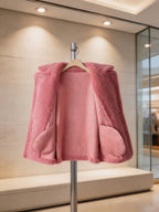 Inside lining and interior pockets view of an open dusty pink shearling pea coat on a stand