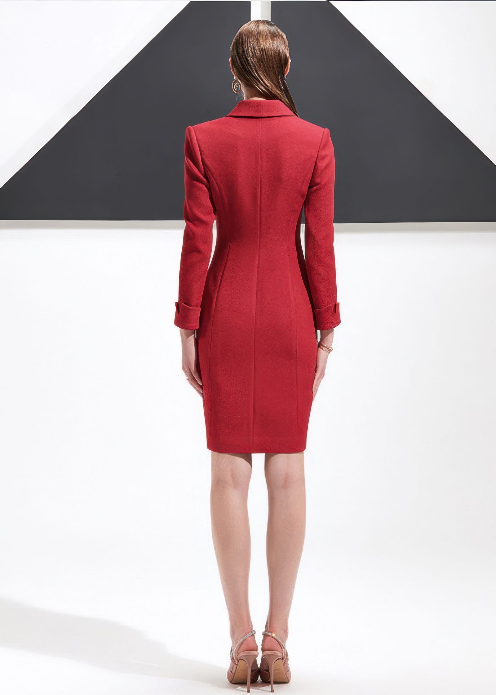 The back view of a woman wearing a tailored red shawl lapel blazer dress, showcasing the structured seams and fit.