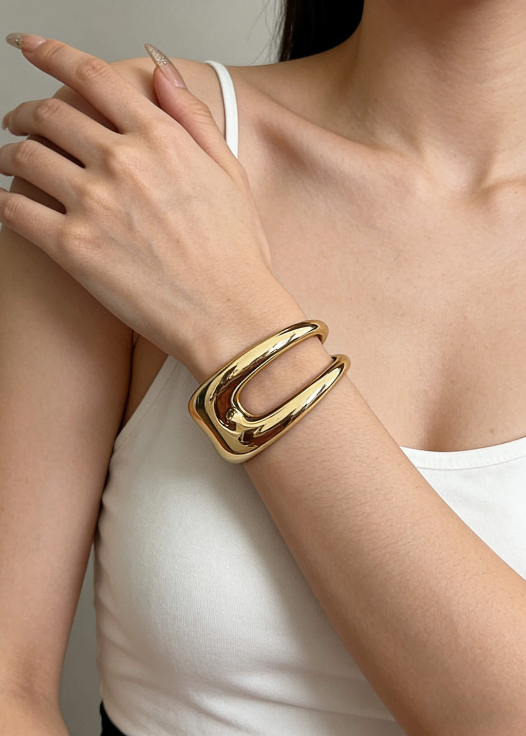 Minimalist styling of the sculptural hollow gold metal cuff bracelet on a model, showcasing its chunky and artistic aesthetic.