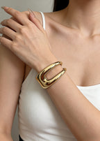 Minimalist styling of the sculptural hollow gold metal cuff bracelet on a model, showcasing its chunky and artistic aesthetic.