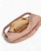 Top view inside open dusty pink soft leather hobo bag showing beige fabric lining and zipper pocket