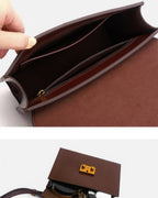 Top-down detailed interior view of an open dark brown leather envelope bag showing the suede lining and main storage compartment.