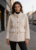 Front view of a female model wearing a winter off-white diamond lattice drawstring shearling wool coat on a city street.